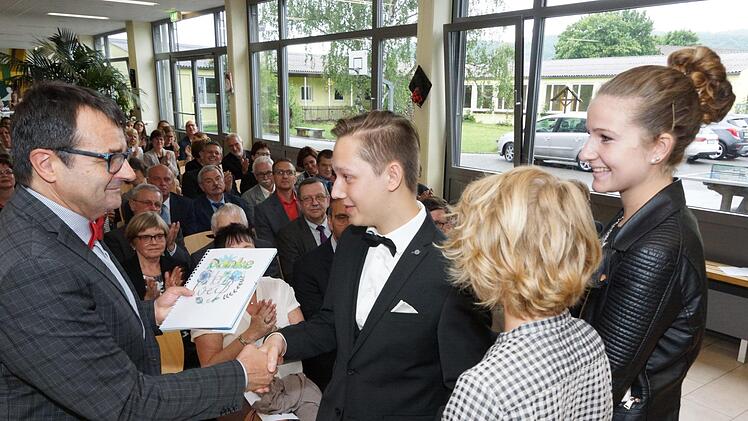 Die Schülersprecher Christian Schiesser, Mika Wüscher und Sarah Schmitt danken Ulrich Weiß mit einem Geschenk. Foto: Arkadius Guzy
