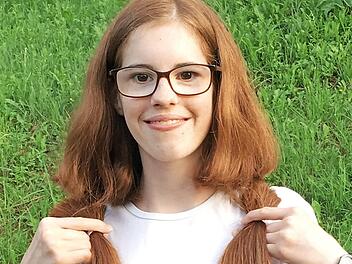 Ab sind sie, die beiden Zöpfe. Maria Förtsch zeigt damit, wie lang ihr Haar einst war.  Foto: Klaus Förtsch