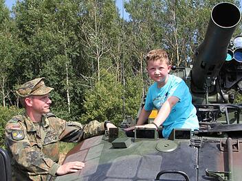 Luca aus Oberwildflecken klettert auf den Waffenträger Wiesel. Feldwebel Denis Hans erklärt dem Sechsjährigen alles ganz genau. Fotos: Ulrike Müller