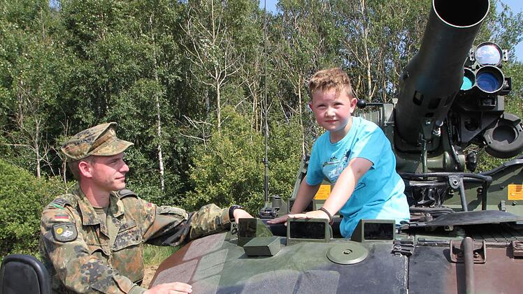Luca aus Oberwildflecken klettert auf den Waffenträger Wiesel. Feldwebel Denis Hans erklärt dem Sechsjährigen alles ganz genau. Fotos: Ulrike Müller