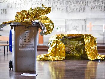 Das Kunstobjekt «Behausung 6/2016» der Künstlerin Romana Menze-Kuhn in Mannheim in der evangelischen Philippuskirche. Eine Reinigungskraft hatte versehentlich Teile der Rettungsfolie, die ursprünglich auf dem Boden lagen, in einen Mülleimer geworfen. Die Künstlerin nutzte den Zwischenfall und baute die Mülltonne in ihr Werk mit ein. Foto: Uwe Anspach/dpa