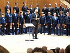 Die Regensburger Domspatzen mit ihrem Domkapellmeister Roland Büchner werden von Erzbischof Ludwig Schick auf der Bühne der Konzerthalle willkommen geheißen.  Foto: Bärbel Meister