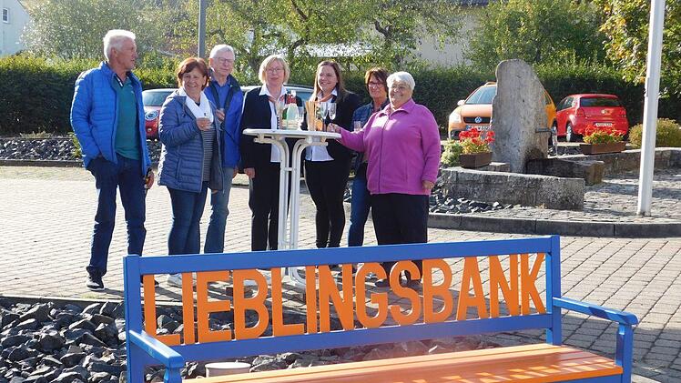 Irmgard Prucha (rechts) freut sich, dass die Lieblingsbank von der VR-Bank rechtzeitig vor den Feierlichkeiten zum 40-jährigen Bestehen des Obst- und Gartenbauvereins Kothen-Speicherz eintraf. Elvira Belz und Svenja Schönstein (4. und 3. von rechts) hatten sie mitgebracht. Walter und Ilse Bug (von links), Norbert Kömpel und Christina Halbleib (2. von rechts) haben das Sitzgefühl schon ausprobiert.  Foto: Kerstin Beck