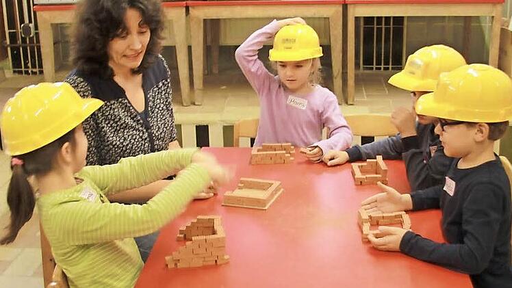 Zusammen mit Kindergartenleitung Ulli Zenker über die Kinder das richtige Mauern. Fotos: Lisa Kieslinger