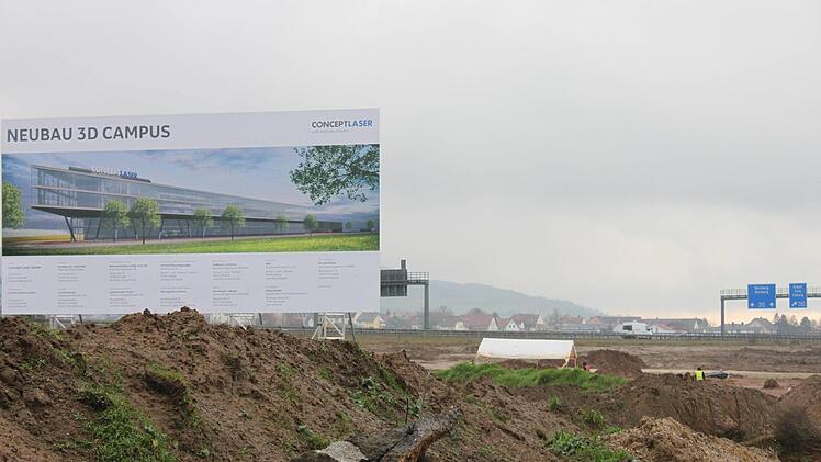 Eine Plakatwand auf dem Gelände nahe A73 und B173 zeigt an, was hier entstehen soll.
