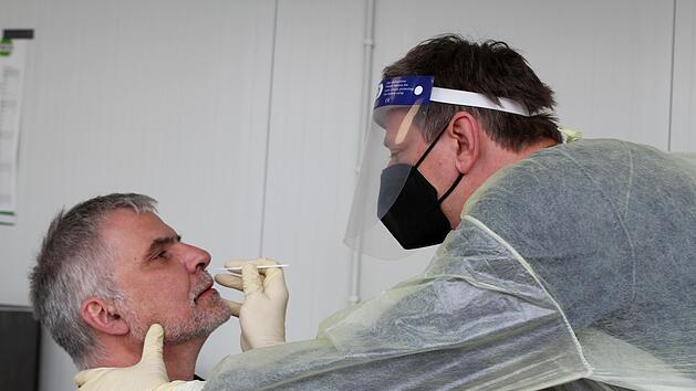 nd jetzt die Nase sch&ouml;&ouml;&ouml;&ouml;n weit aufmachen! Andreas Schilde (rechts) nimmt bei Oliver Reinsberg einen Corona-Schnelltest vor.