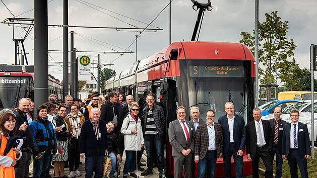 Beim mobilen Dialogforum zur Stadt-Umland-Bahn ging es mit einer angemieteten Straßenbahn auf Besichtigungstour durch das Nürnberger Stadtgebiet. Begleitet wurde die Fahrt von zwei Vertretern der VAG, den drei Stadtoberhäuptern aus Erlangen, Herzogenaurach und Nürnberg sowie den beiden Leitern des Zweckverbands Stadt-Umland-Bahn (von links nach rechts vor der Straßenbahn).     Foto: Grischa Jäger