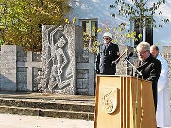 Zweiter Bürgermeister Gerhard Zösch (am Rednerpult) ging in seiner Rede auf Einzelheiten der Neugestaltung des Kriegerdenkmal-Umfeldes ein, bevor die Gemeindereferenten Rudi Reinhart (verdeckt) und Helmut Leykauf (Zweiter von rechts) die Anlage segneten. Rechts steht Dritter Bürgermeister Paul Hümmer.  Foto: ab