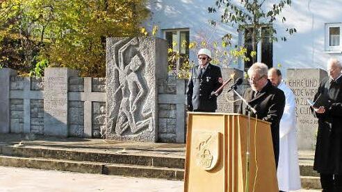 Zweiter Bürgermeister Gerhard Zösch (am Rednerpult) ging in seiner Rede auf Einzelheiten der Neugestaltung des Kriegerdenkmal-Umfeldes ein, bevor die Gemeindereferenten Rudi Reinhart (verdeckt) und Helmut Leykauf (Zweiter von rechts) die Anlage segneten. Rechts steht Dritter Bürgermeister Paul Hümmer.  Foto: ab