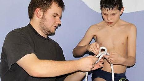 Derweil übt Trainer Sebastian Statt mit Robin Schneider, wie man verschiedene Knoten macht.