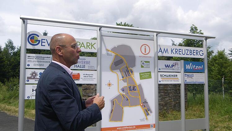 Bürgermeister Gerd Kleinhenz erklärt anhand der neuen Schautafel des Gewerbeparks am Kreuzberg die Veränderung und Chancen Wildfleckens im Zuge der Konversion. Foto: Regina Rinke