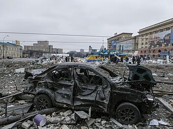 Ukraine, Charkiw: Der zentrale Platz liegt nach dem Beschuss des Rathauses in Trümmern. Russische Granaten beschossen am Dienstag zivile Ziele in der zweitgrößten Stadt der Ukraine, Charkiw, während ein über 60 Kilometer langer Konvoi von russsischen Militärfahrzeugen auf die Hauptstadt Kiew zurollt. Foto: Pavel Dorogoy/AP/dpa