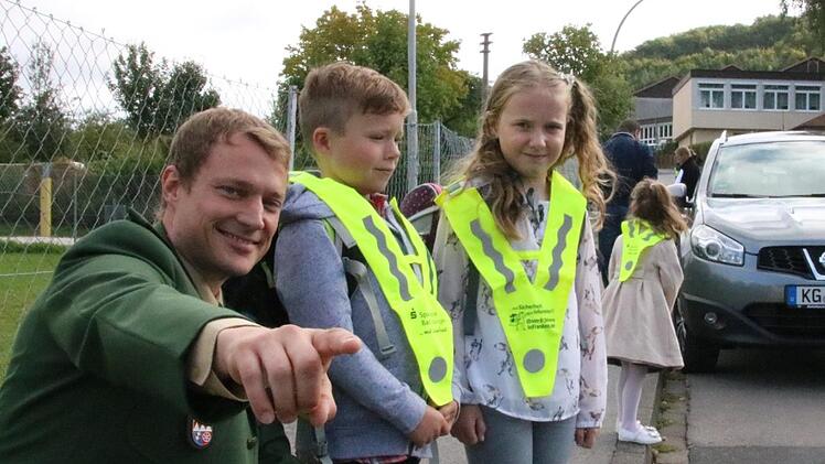 Verkehrserzieher Stefan Löhser zeigt den Abc-Schützen Hannes und Lavinia das richtige Verhalten beim Überqueren der Straße.  Foto: Ralf Ruppert