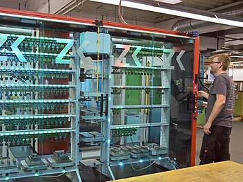 Wie von Geisterhand gesteuert arbeitet der Roboter, von vielen Lichtsignalen begleitet, selbstständig in der Automationszelle. Werkzeugmechaniker Norman Schwabe wirft einen Blick in die im Hundertstel-Millimeterbereich funktionierende Präzisionsarbeit.  Foto: K.- H. Hofmann