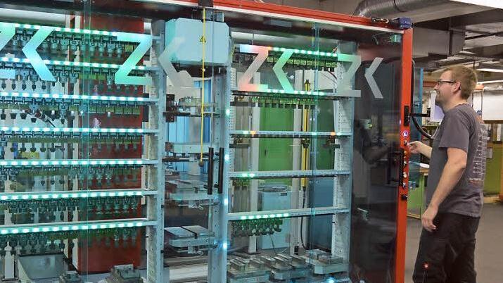 Wie von Geisterhand gesteuert arbeitet der Roboter, von vielen Lichtsignalen begleitet, selbstständig in der Automationszelle. Werkzeugmechaniker Norman Schwabe wirft einen Blick in die im Hundertstel-Millimeterbereich funktionierende Präzisionsarbeit.  Foto: K.- H. Hofmann