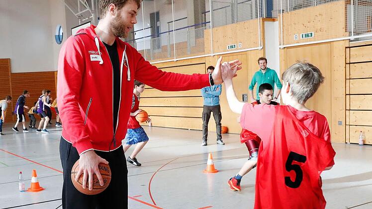 Nicolo Melli (Brose Bamberg) klatscht die Kinder ab. Foto: Daniel Löb