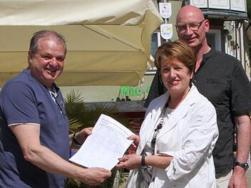 Thomas Dittmayer übergibt die Unterschriften an Bürgermeisterin Brigitte Meyerdierks und Wirtschaftsreferenten Hartmut Bös. Foto: Ulrike Müller
