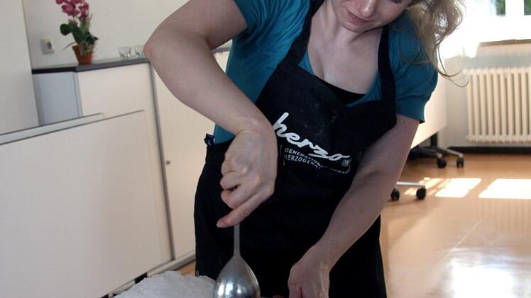 Simone Voit gibt Salz zum Eis, um die Kühlwirkung zu erhöhen.