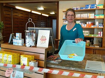 Rezept ins Körbchen hin, Medikament im Körbchen zurück: Brigitte Raetsch achtet in ihrer Apotheke in Coburg darauf, dass die Sicherheitsabstände zwischen den Kunden und Apothekenmitarbeitern gewahrt werden. Foto: Simone Bastian
