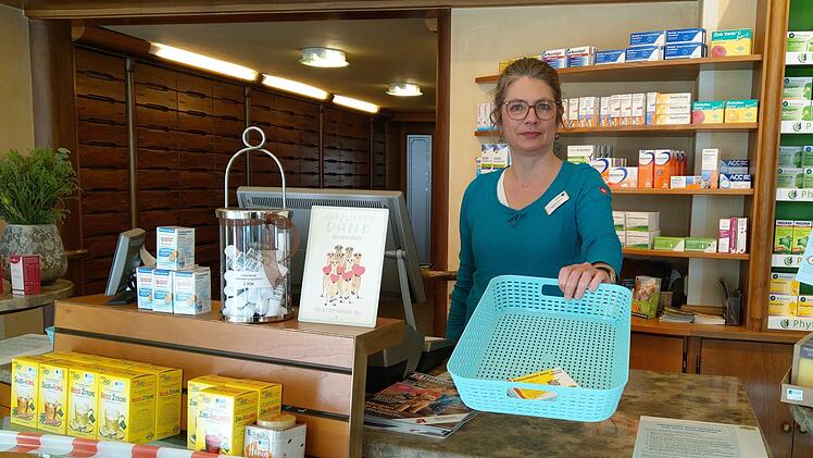 Rezept ins Körbchen hin, Medikament im Körbchen zurück: Brigitte Raetsch achtet in ihrer Apotheke in Coburg darauf, dass die Sicherheitsabstände zwischen den Kunden und Apothekenmitarbeitern gewahrt werden. Foto: Simone Bastian