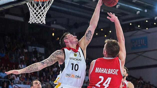 Der Bamberger Daniel Theis (Nr. 10) blockt einen Wurf des &ouml;sterreichischen Topscoreres Rasid Mahalbasic. Der k&uuml;nftige NBA-Profi Paul Zipser (links) beobachtet die Situation.  Foto: Nicolas Armer/dpa