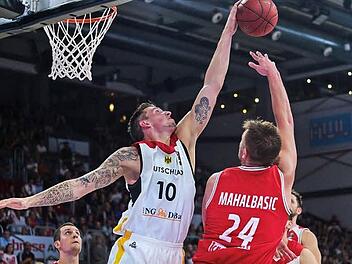 Der Bamberger Daniel Theis (Nr. 10) blockt einen Wurf des österreichischen Topscoreres Rasid Mahalbasic. Der künftige NBA-Profi Paul Zipser (links) beobachtet die Situation.  Foto: Nicolas Armer/dpa