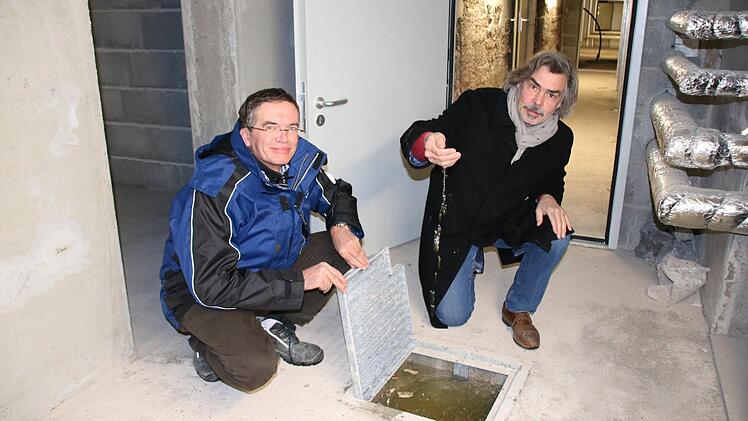 Das komplette Luitpoldbad wurde mit einer dicken Betonsohle vor Auftrieb geschützt. Hier prüfen (von links) Hartmut Holzheimer und Architekt Christian Teichmann den Wasserstand in einem Pumpenloch. Foto: Ralf Ruppert