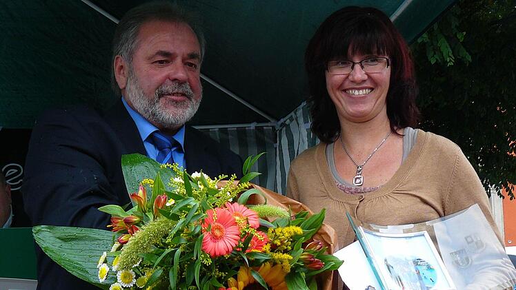 Bürgermeister Norbert Volk belohnte Ariane Suttner mit einem Blumenstrauß. Die Frau hatte einem dreijährigen Buben im Helmbrechtser Bad gerettet.