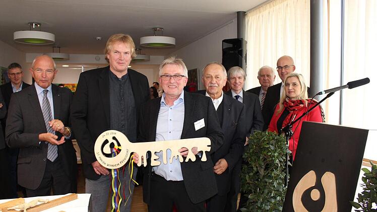 "Heimat” ist auf dem symbolischen Schlüssel zu lesen, den Architekt Markus Hirt (Dritter von links) dem Wohnheimleiter Georg Schmitt (Vierter von links) übergab.  Foto: Seeger