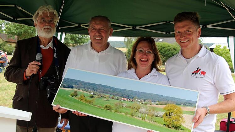 Mit einer neuen Dorfansicht fürs Gemeindehaus überraschte der Heilgersdorfer Wilfried Staub die Organisatoren des Fests Günther Schramm, Petra Grell und Udo Jahn (von links). Foto: Bettina Knauth