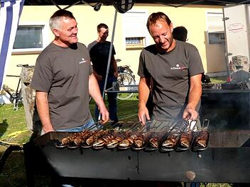 Konrad Dellermann und Florian Utz kümmern sich beim Dorffest in Wiesendorf um die Makrelen. Fotos: Johanna Blum
