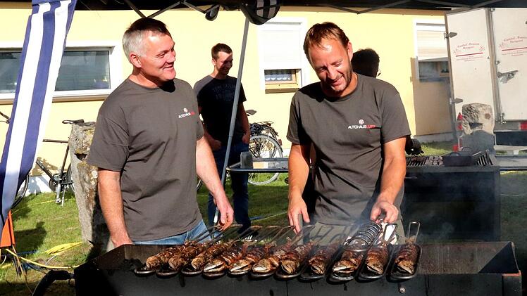 Konrad Dellermann und Florian Utz kümmern sich beim Dorffest in Wiesendorf um die Makrelen. Fotos: Johanna Blum