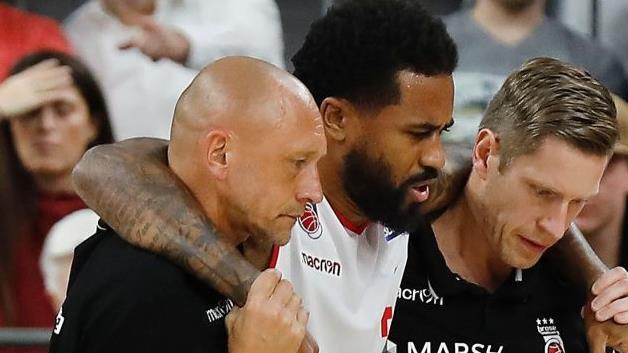 Bryce Taylor verletzte sich im Dezember 2017 schon einmal schwer  und fiel &uuml;ber Monate aus. Hier wurde er damals von Teamarzt Andreas F&ouml;rst (links) und Physiotherapeut Kilian Flierl  begleitet, die den 33-J&auml;hrigen  nun in der Reha betreuen werden.Archiv/L&ouml;b