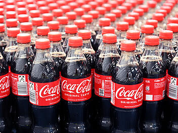 Am Produktionsstandort Mannheim von Coca-Cola Europacific Partners - CCEP Deutschland GmbH werden abgefüllte 0,5 Liter Einweg Coca-Cola Flaschen über ein Förderband transportiert.