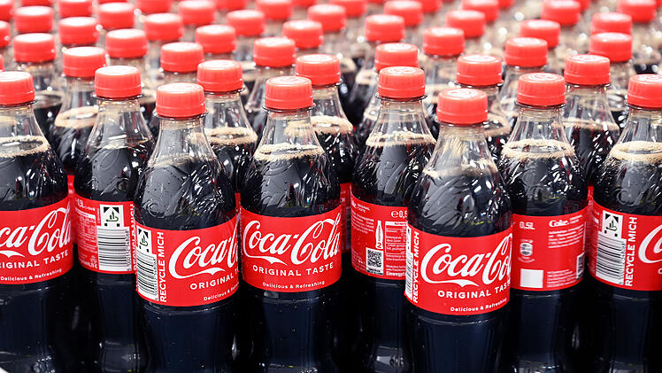 Am Produktionsstandort Mannheim von Coca-Cola Europacific Partners - CCEP Deutschland GmbH werden abgefüllte 0,5 Liter Einweg Coca-Cola Flaschen über ein Förderband transportiert.