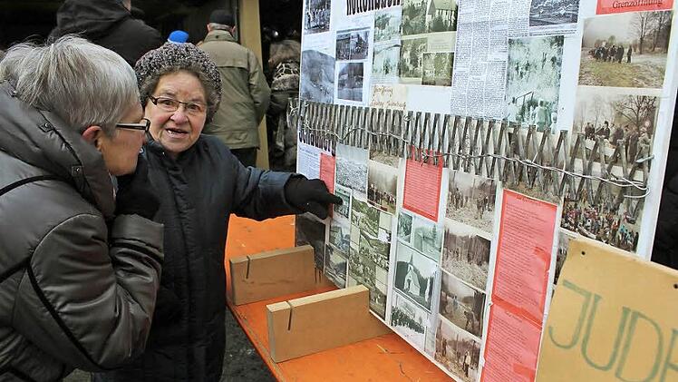 Elisabeth Förster wirft interessiert einen Blick in die Zeitungsberichte, in denen das Haus in Röttenbach abgebildet ist, in dem sie lebte und das dem Erdboden gleich gemacht wurde. Foto: Uwe W. Zipfel