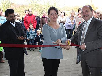 Bürgermeister Wolfgang Fees schneidet zusammen mit der Kita-Leiterin Kerstin Lorenz und Kaplan Solomon das symbolische Band an der neuen Kinderkrippe durch.  Fotos: fra-press