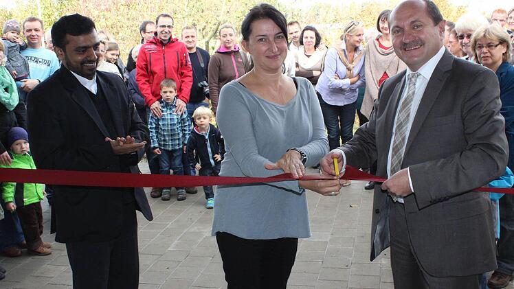 Bürgermeister Wolfgang Fees schneidet zusammen mit der Kita-Leiterin Kerstin Lorenz und Kaplan Solomon das symbolische Band an der neuen Kinderkrippe durch.  Fotos: fra-press