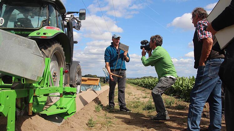 Den Pflanzspaten, den Karl Brehm (Mitte) in der Hand hält, braucht der Bio-Landwirt dank einer technischen Erfindung nicht mehr für das Setzen der Meerrettich-Pflanzen. Er erklärt vor Ort den Jurymitgliedern, wie sein Gerät funktioniert.  Foto: Sarah Dann