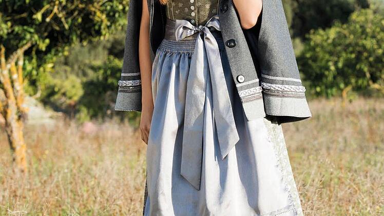 Der dunkelgraue Trachten-Poncho mit Applikationen in Silber passt ideal zum edlen Dirndl.  Foto: Krüger Dirndl
