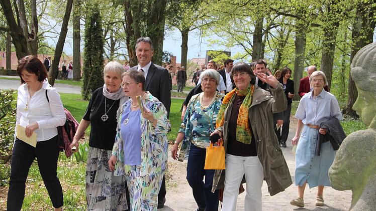 Beobachtet von den steinernen Putten schlendern die Gäste durch den Park.