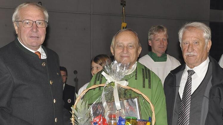 Wallfahrtsleiter Otmar Lutz (links) und sein Vorgänger Otmar Seidl (rechts) übereichten Pfarrer Gerold Postler zum Abschied  einen Präsentkorb. Foto: Peter Klopf