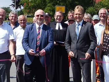 Die Gemeindeverbindungsstraße von Hain nach Wildenberg ist fertiggestellt. Dies wurde gefeiert. Unser Bild entstand bei der festlichen Eröffnung mit dem Durchschneiden des Bandes durch die beiden Bürgermeister Bernd Rebhan aus Küps (vorne, rechts) und Egon Herrmann aus Weißenbrunn (vorne, links). Foto: Dieter Wolf