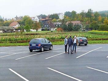Bürgermeister Andreas Hügerich und Stadtbaumeister Jürgen Graßinger unterhalten sich auf dem auf 70 Stellplätze erweiterten Pendlerparkplatz mit einem Parkplatznutzer. Foto: Alfred Thieret