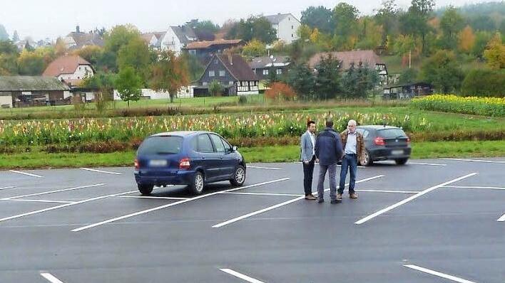 Bürgermeister Andreas Hügerich und Stadtbaumeister Jürgen Graßinger unterhalten sich auf dem auf 70 Stellplätze erweiterten Pendlerparkplatz mit einem Parkplatznutzer. Foto: Alfred Thieret