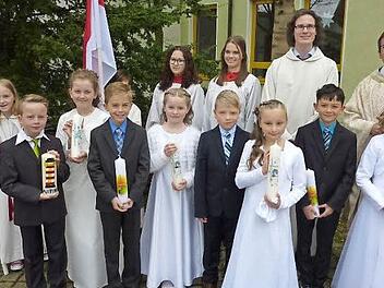 Annika Büsch, Lina Detsch, Jamie Martin, Emily Pötzinger, Elias Renk, Marie Schubert, Anton Schülner und Jakob Wachter feierten ihre Erstkommunion. Mit im Bild sind Gemeindereferent Matthias Beck, Pfarrer Hans-Michael Dinkel (rechts) sowie einige Ministranten. Foto: Gerd Fleischmann