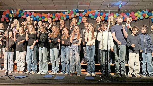 Die Band- und Chorklasse 6C steht mit dem Schulchor auf der B&uuml;hne.