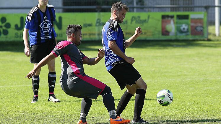 Christoph Neumeister (r.) schirmt den Ball vor dem Erlacher Markus Merckel ab; links hinten Ralf Kohler