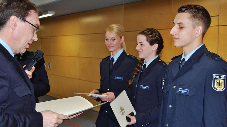 Die drei Lehrgangsbesten (von links) Nathalie Göschl (3. Platz), Helena Krieger (2. Platz) und Pascal Nordgauer (1.Platz) werden von Polizeidirektor Thomas Lehmann zu Polizeimeistern befördert. Foto: Sigismund von Dobschütz