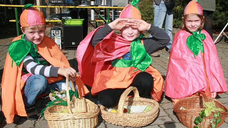 "Die echten Kürbisse sind wir", sagten Brian Schackow, Jannes Feulner (beide 6) und Eva Glauer (5) - und verteilten an die Kürbismarktbesucher Äpfel.